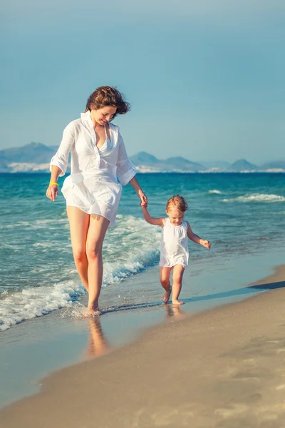 Mother and daughter walking on the beach