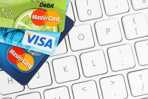 Cards Visa and MasterCard are placed on white keyboard background