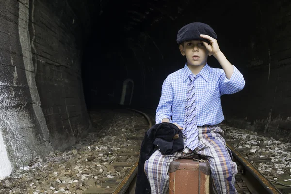 Child sits on railway road