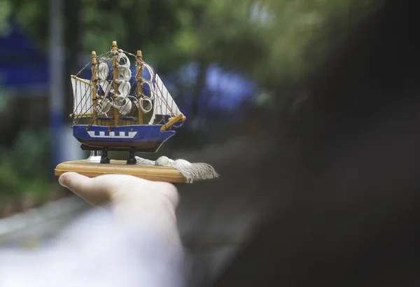 Hand holding model of sailing ship
