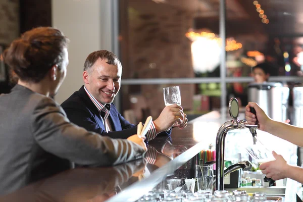 People, leisure, friendship, communication - happy male friends drinking beer and talking at bar