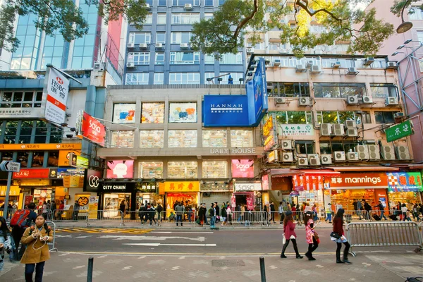 Pedestrians walking on busy street with bright showcases of shopping malls