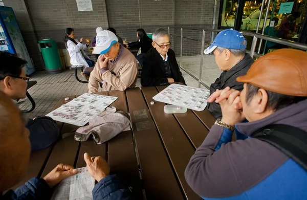 Older men play the ancient Chinese strategic game of Go during holidays