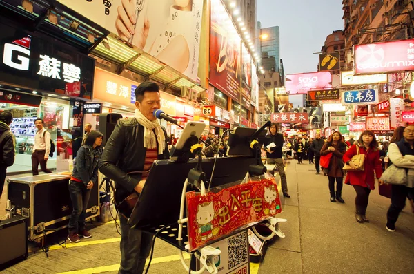 Rock musician sing a song during street performance in the bustling city