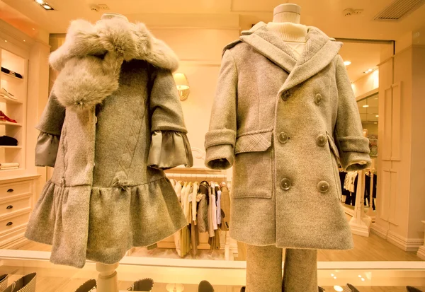 Warm woolen coats for children in the window of a luxury fashion store