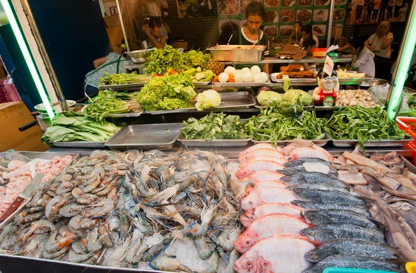 Seafood market stall with shrimps, brines, fish on popular food market street