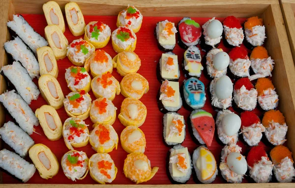 Set of appetizers and sushi on display of fast-food shop