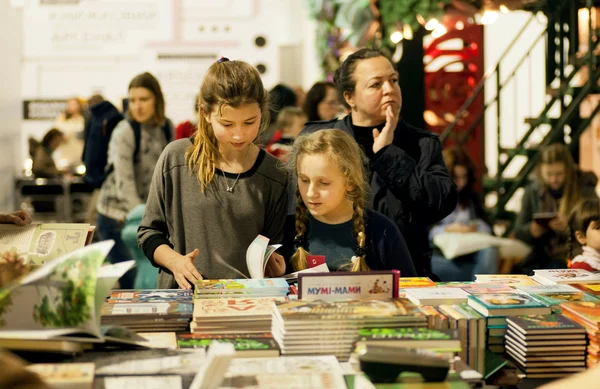 Unidentified girls reading books at children booth of the 6th International Festival BOOK ARSENAL