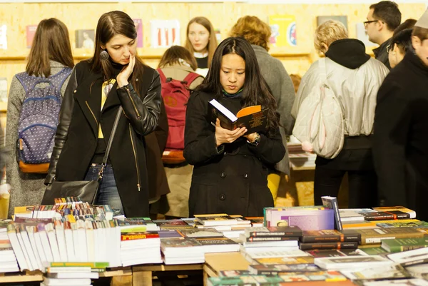 Cute women reading new books in crowd of readers