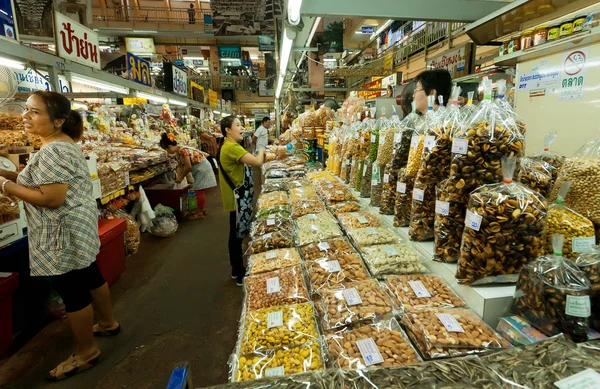 Women shopping at big market with spices, beans, fresh vegetables and exotic food