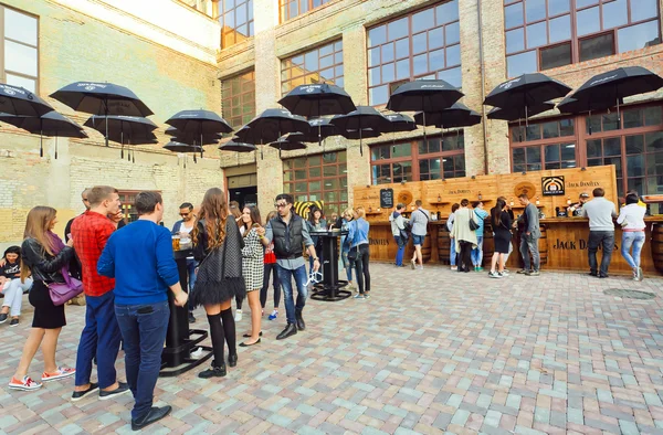 Outdoor bar with umbrellas and crowd of drinkig people