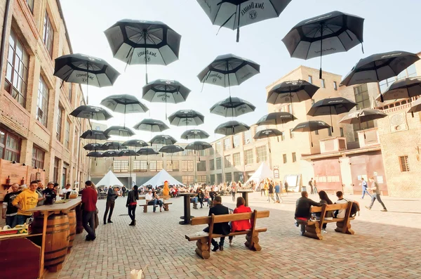 People relaxing under umbrellas at outdoor bar of city