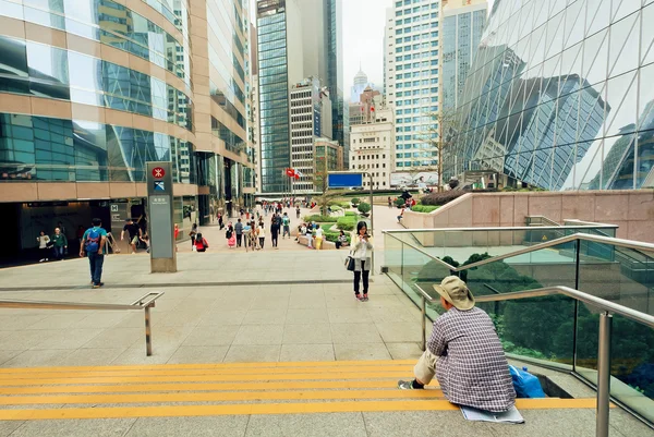 People making pictures and walking around downtown with skyscrapers and modern architecture structures