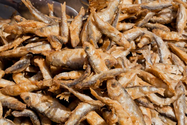 Many small fish fried in oil and ready for food supply