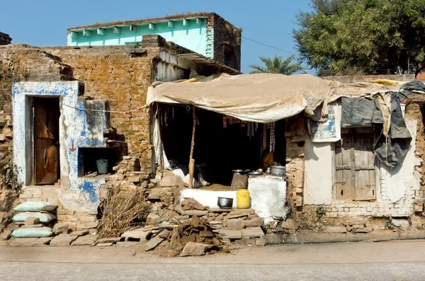 Poor indian family house with broken walls on dirty street