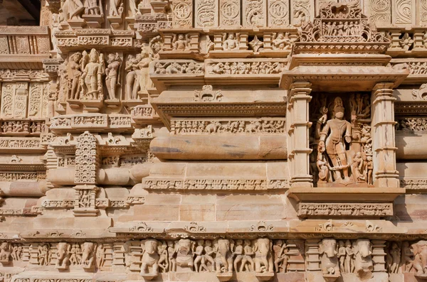 Brick wall with reliefs of Hindu temple of Khajuraho, India. UNESCO Heritage site, belong to Hinduism and Jainism.