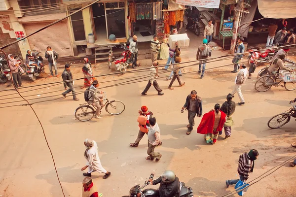 Top view on people walking and cyclists riding on busy street of indian city