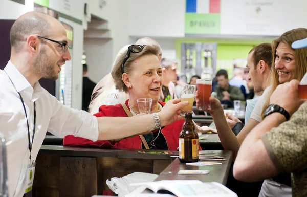 Meeting of old friends with glass of beer at the bar of noisy event