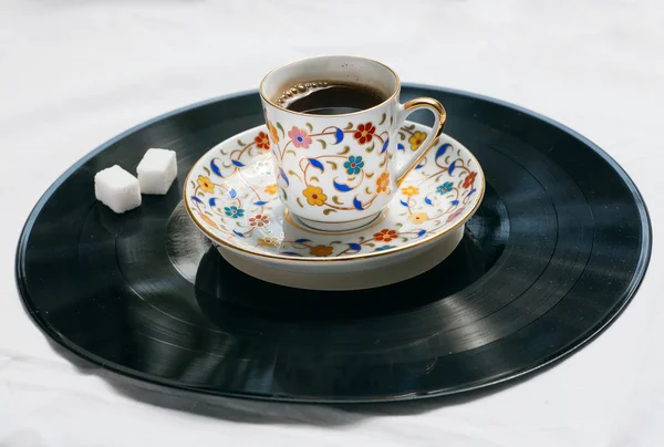 Song of a morning concept. Retro sound vinyl plate and cup of coffee with sugar.