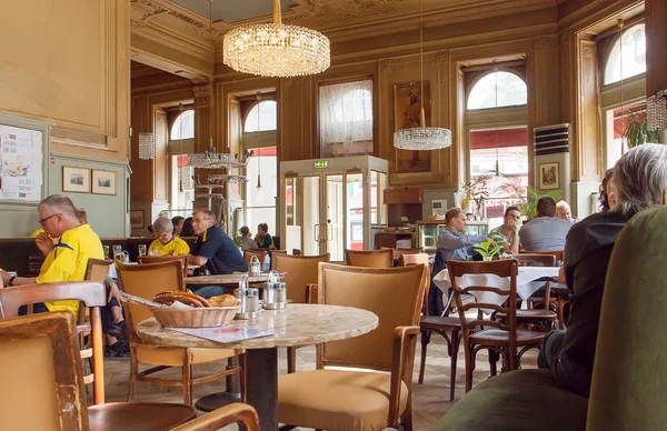 Interior of historical cafe with pelaxing people, big windows and retro furniture. Vienna