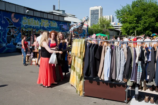 Women looking for second hand clothes and used items on the open air flea market