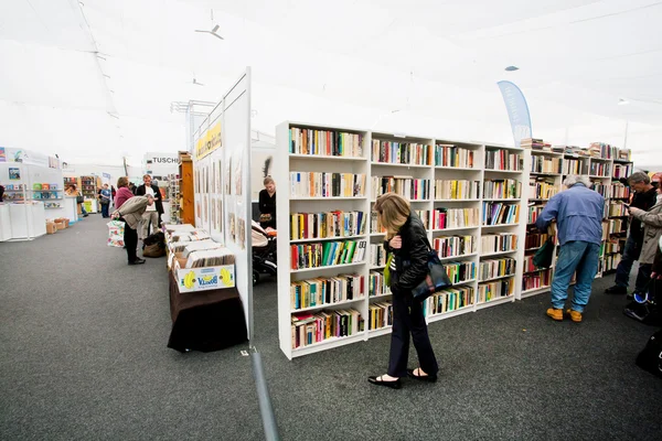 Many men and women choose books at the indoor book market