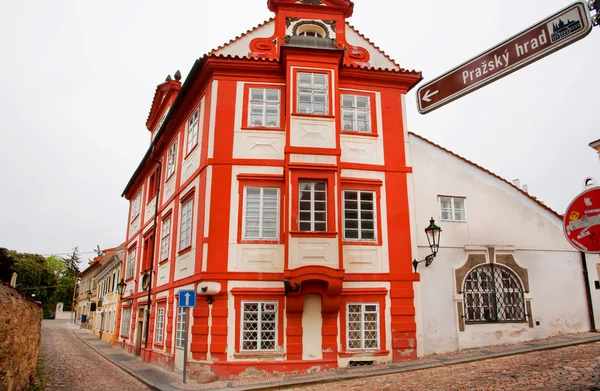 Red house inside the historical Hradcany district with cobbled streets and old houses