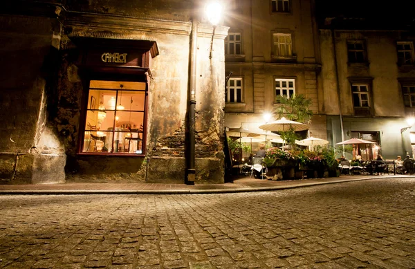Dark street of old city with cobble stone road and bars and cafes around