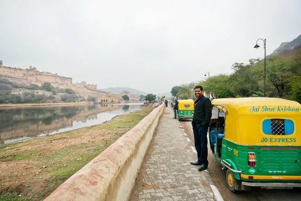 Handsome driver near the indian moto rickshaw