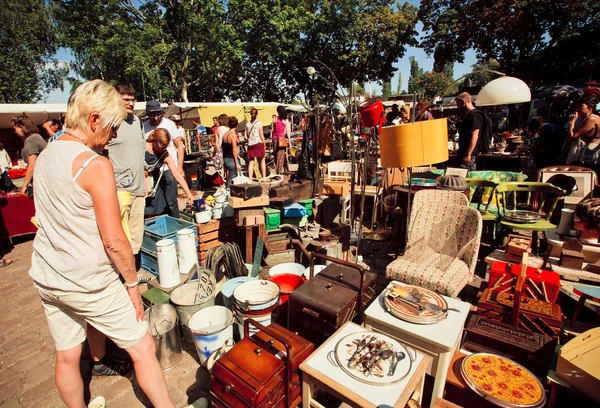 Flea market with people choosing vintage furniture