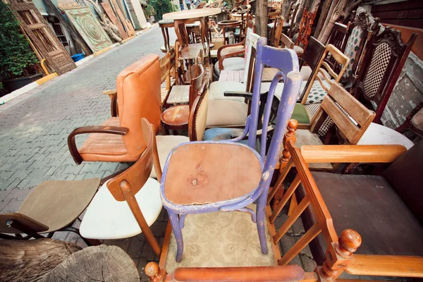 Garage sale with wooden furniture and different chairs