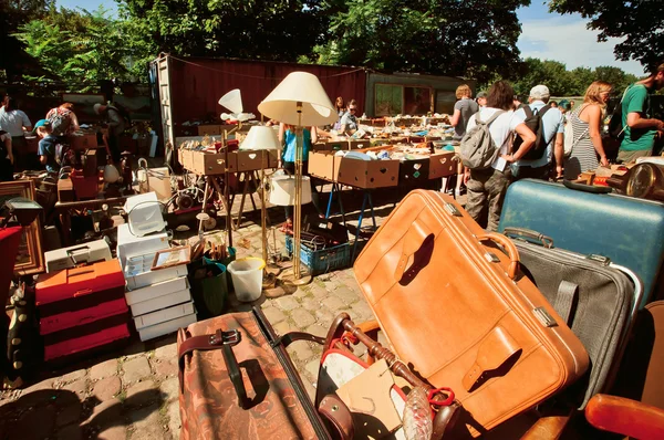 Leather bags and utensils on sale with a crowd of shoppers