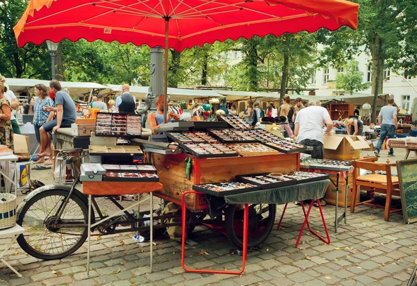 Crowded flea market with creative stands of vintage glasses and merchandise