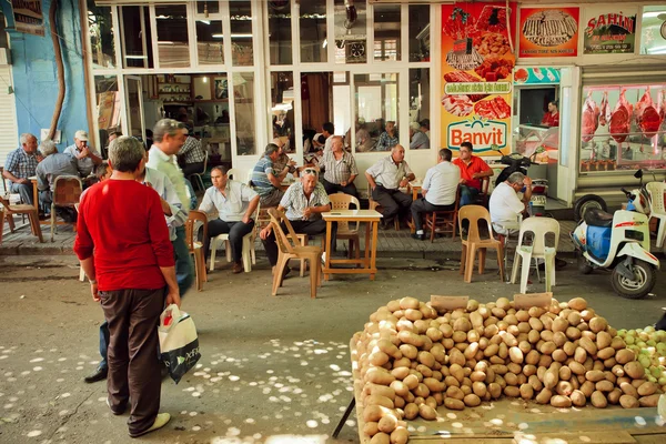 Many men drinking tea and talking in tea garden near the vegetable market of Sirince village