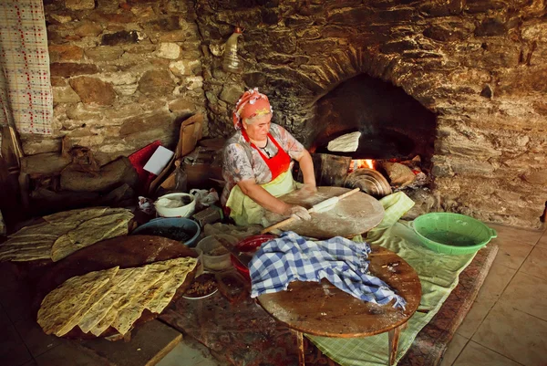 Elderly woman cooking traditional Gozleme dish rustic stone oven of old turkish village