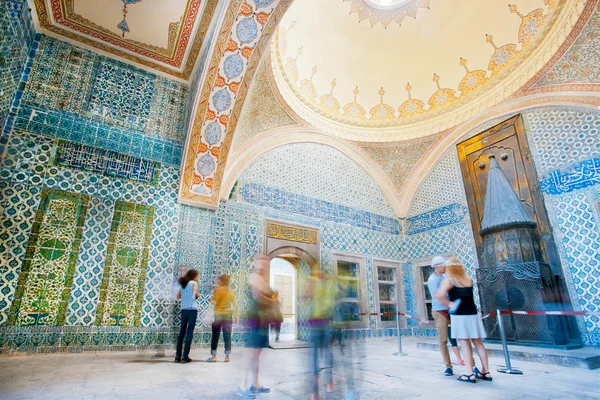 Inside of great Topkapi palace with colorful tiles and walking tourists, Turkey