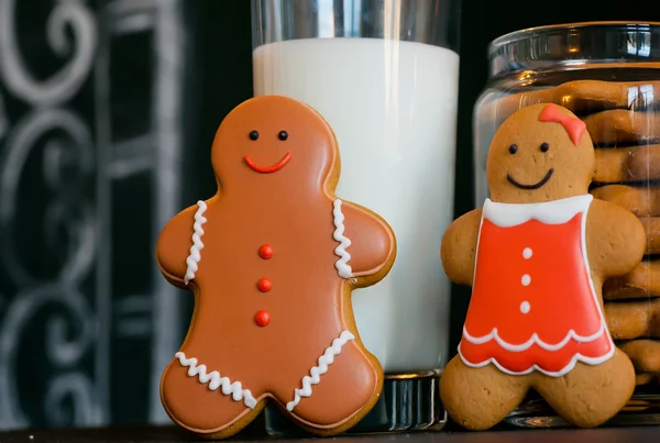 Happy gingerbread family smiling past a glass of milk