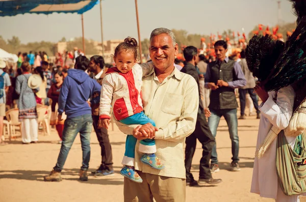 Unidentified child and father having fun in crowd of people during the Desert Festival