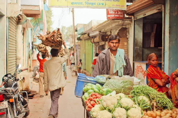 Street trader bringing carrots, zucchini, cauliflower to village vegetable market of indian city