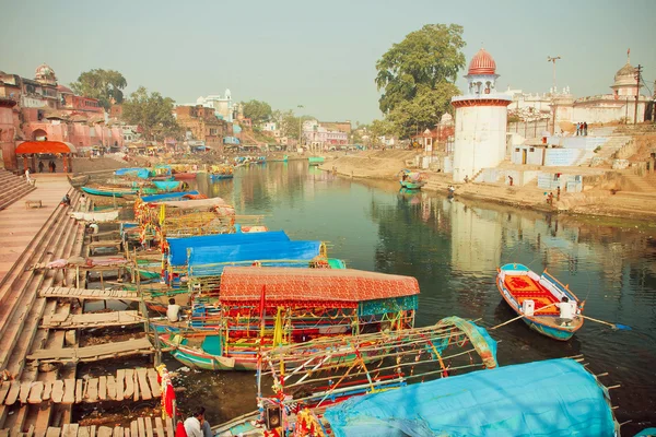 Colorful riverboats floating on the quiet water river of indian city with historical houses