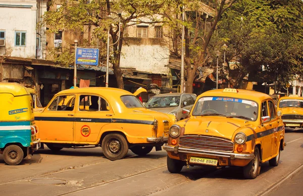 Yellow taxi car driving on the busy street of indian city