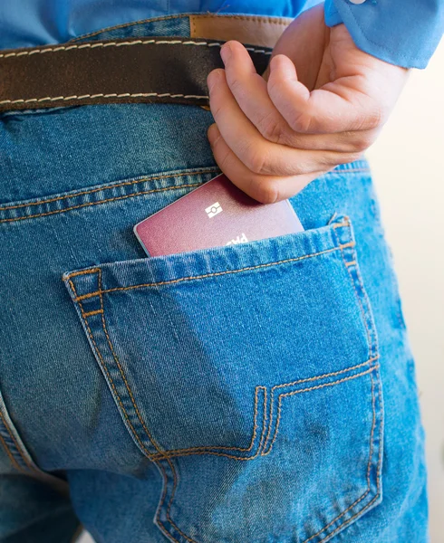Man pulls out european passport from his back pocket.