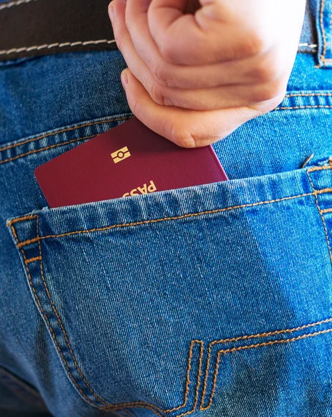 Man pulls out european passport from his back pocket.