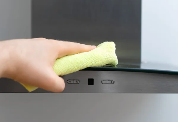 Man\'s hand wipes dust from exhaust hood.