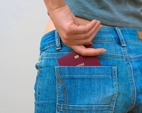 Woman pulls out european passport from his back pocket.