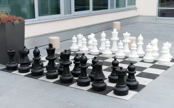 Outdoor chess board with big plastic figures.