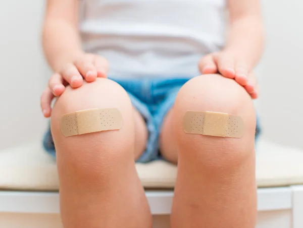 Child knee with an adhesive bandage.