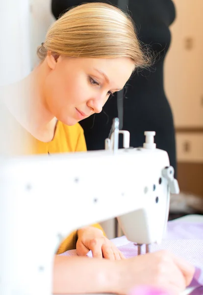 Woman working on sewing machine in the factory.