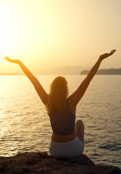 Woman with arms wide open at sunset. Place for text.