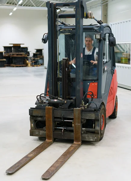 Handsome forklift operator working in the warehouse.